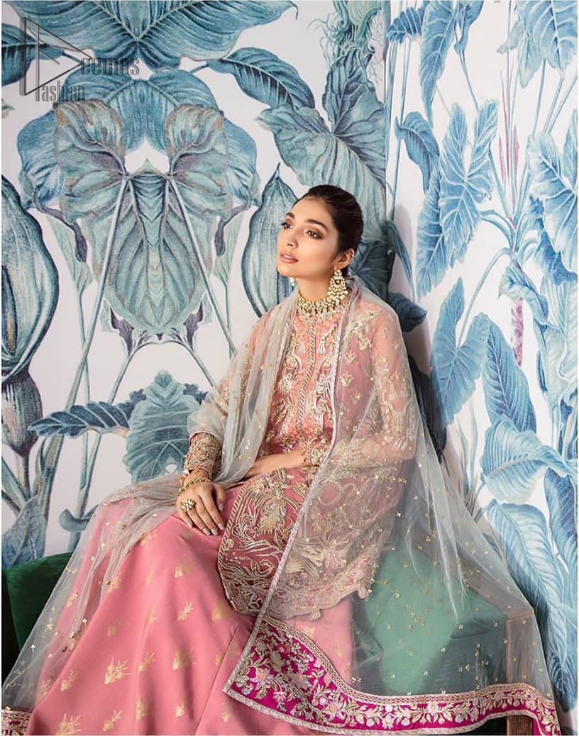 Let the crowd stare and make it worth their while when you walk wearing this outfit. A perfect ensemble for this festive season with divine detailing of thread embroidery, color balance and well-crafted applique hemline. The front open frock is fully embellished with floral embroidery done with light golden zardozi work and thread embroidery. It comprises with pink self fabric sharara and mint green dupatta, adorned with sequins spray on the ground and embellished pink applique pallu. You would definitely want to wear this for your next occasion.