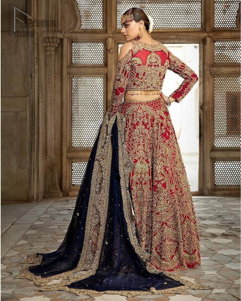 A breathtaking red traditional lehenga paired with a detailed blouse, equally alluring make for an ensemble which is comfortably chic. The blouse is done with golden and antique shaded embroidery and finishing with tassels. Blouse having cold shoulder full sleeves. The lehenga is enhancing with the art of classical heritage showcasing the craftsmanship of kora, dabka, tilla, kundan and sequins detailed, artistically embellished to give a beautiful rhythm to the outfit. It comprises with navy blue dupatta sprinkled with sequins and four sided scalloped border. This is an ensemble that is sure to invite compliments galore.