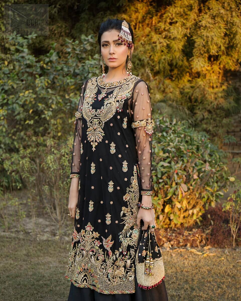 This elegant ensemble turns timeless piece into a chic fantasy. Steal the show with this endearing chiffon outfit with intricate yet rich embroidery. Artfully crafted neckline with detailed golden zardozi work. The hemline is ornamented with a central large motif and adorned with jaal. Furthermore, side slits are also decorated with floral embroidery and floral motifs are decorated with multiple color thread embroidery. The back is perfectly loaded with zardozi work. This outfit is comprises with black sharara and chiffon dupatta having sequins spray all over.