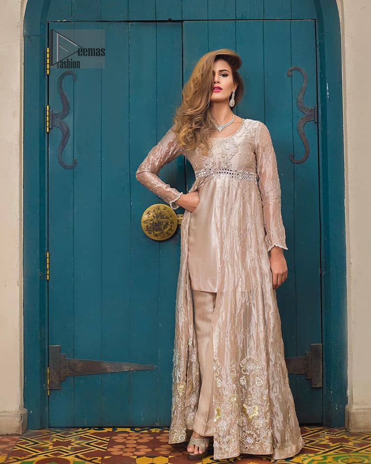 This dress is majestic beauty. Delicately crafted and personifying chic elegance with an element of grandiose. The gown is beautifully decorated with floral bunches done with silver kora, dabka, tilla and sequins work. The bottom of the gown is enhanced with rich floral embroidery. Style it up with hand embellished fixed waist belt. It comprises with cameo straight pantsa. This outfit is coordinated with chiffon dupatta having sequins spray all over.