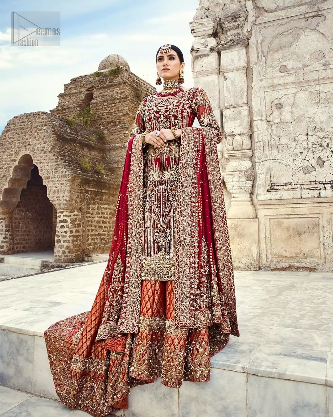 You are all set to make a lasting impact with the divine royalty of this dress. This beautiful dress comes with a maroon back train lehenga with beautiful embellishment around the hem. The shirt is adoned with golden zardozi work around the neckline and vertically worked gold lines and it finished with a thick embellished border. The sleeves are embellished with motifs all over along with a thick embroidered border. The dupatta incorporates beautifully designed borders on all four sides, focusing on the heavily embellished pallu borders to give it a perfect maharani look.