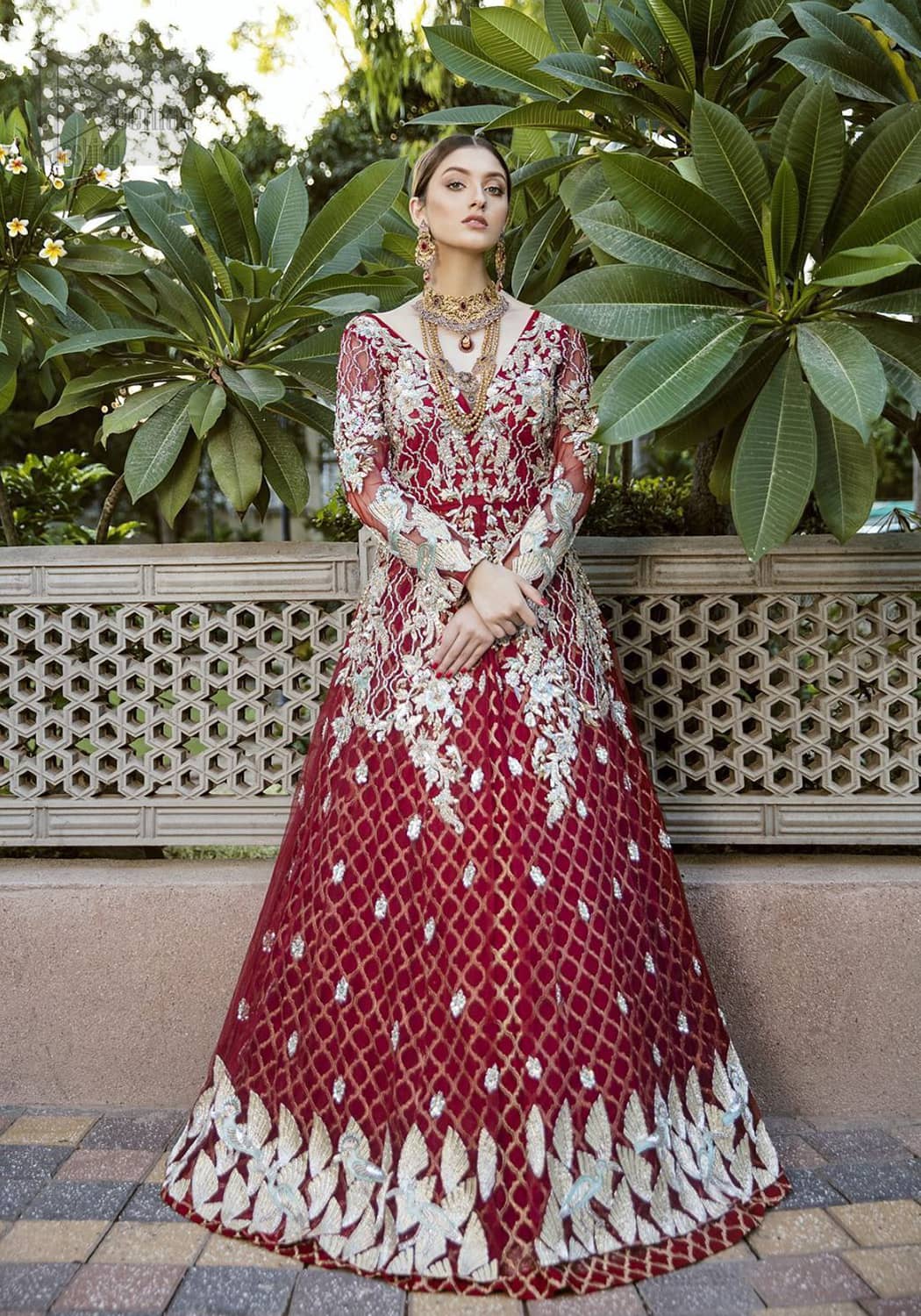 This front open marron maxi is creating a dreamy composition. The chic yet elegant front open maxi is decorated with floral embroidery , heavily embellished bodice and floral bunches. Hemline is even more enhanced with birds motifs finished with jamawar lining adorned with geometric patterns in it. The embroidery is done with silver and white kora, dabka, tilla, and pearls. It comes with straight trousers allured with sprinkled motifs on dupatta dupatta finished with silver lace all around the edges.  