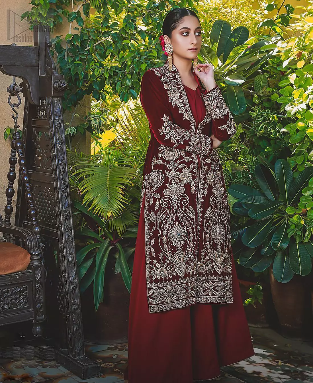 Steal the show with this endearing velvet outfit with intricate yet rich embroidery. The chic yet elegant front open shirt is decorated with embroidered patterns, embellished collar neckline and floral bunches. Hemline is even more enhanced with detailed zardozi work. The back of the shirt has a central large motif on the bodice while the zardozi work creates drama on both front and back panels. Beautifully paired up with maroon palazzo pants. Finish the look with maroon organza dupatta adorned with tiny floral motifs all over.