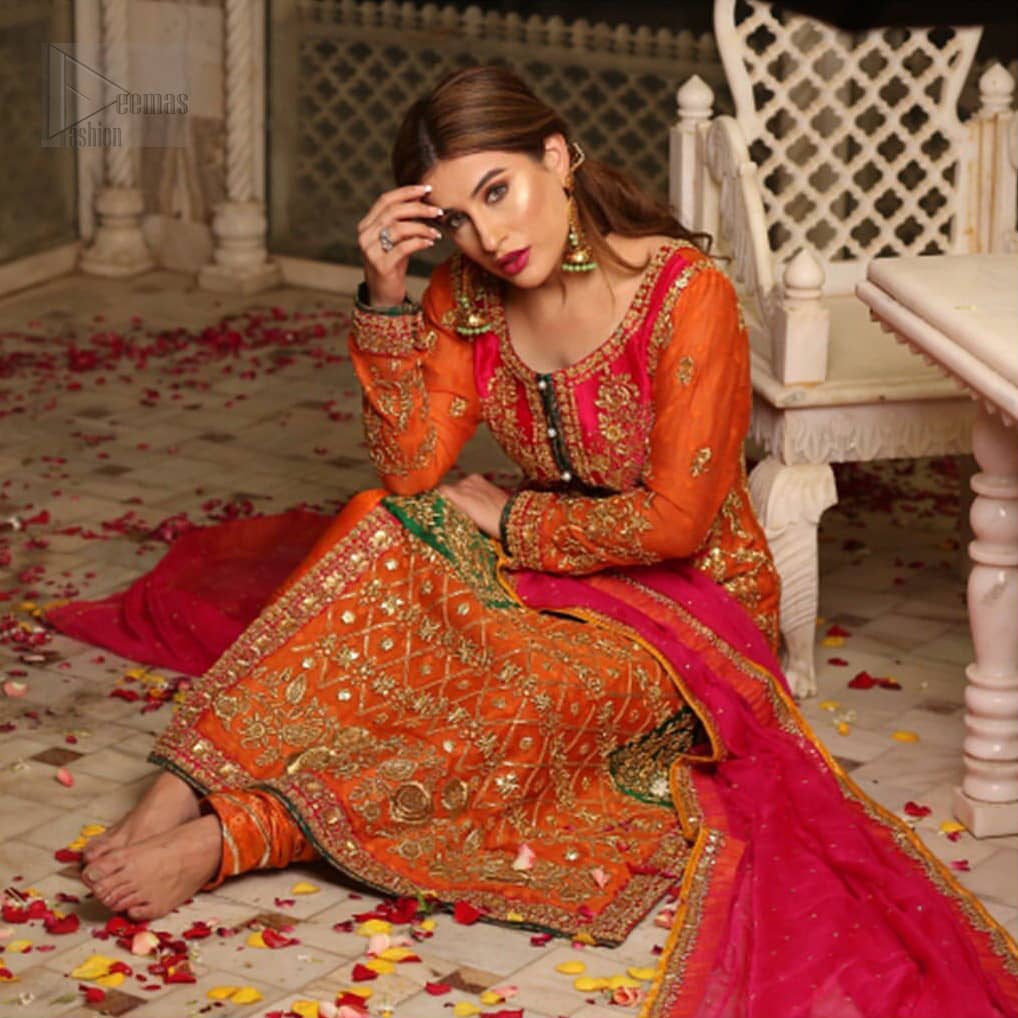 Get bold and beautiful with this uber-stylish ensemble that has flattering cuts, and a colour palette that is bewitching. This orange long shirt adorned with intricate tilla work, kora, dabka and sequins is perfect ensemble for mehndi. Furthermore the shirt is also highlighted with pink embellished bodice and rest of the shirt is enhanced with geometric gota embroidery and green applique instantly draws attention.. It comprises with orange pajama adorned with gota work. Paired with pink chiffon dupatta with kiran lace finishing all around the edges that gives the right amount of glamour to the outfit.
