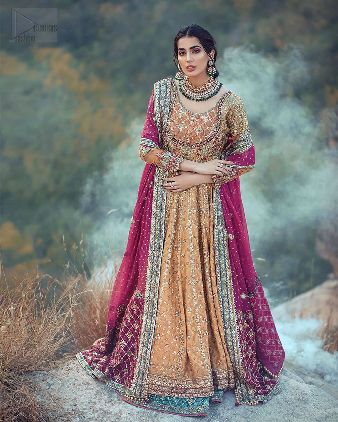 This exceptionally detailed anarkali frock is cut in a seductive fit and flare silhouette that’s sure to turn heads. The bodice with round neckline is adorned in richly beaded work with fabulous sparkle and zardozi work. Furthermore the panels of the shirt is vertically adorned with golden kora, dabka, tilla work and various flora motifs meticulously using on the ground. The frock is comprises with ferozi lehenga emphasized with criss cross patterns done with golden embellishment. Elegance is personified when it gets paired up with an embroidered dupatta with alternating motifs and sequins detailing.