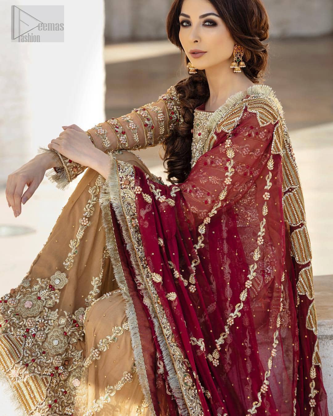 Picturing your bridal in a glowing fawn color. Featuring beautiful handwork, this outfit has a delicate arrangement of hand embellished geometric patterns with pearls and crystals on the bottom. Refined craftsmanship is at its best with hand embellished bodice which is laden with zardozi work. This outfit is paired with organza gharara with embroidered bottom and kiran lace, and maroon dupatta ornamented with geometric patterns along the length, making it a statement piece. Furthermore it is also enhanced with kiran lace on all four sides.