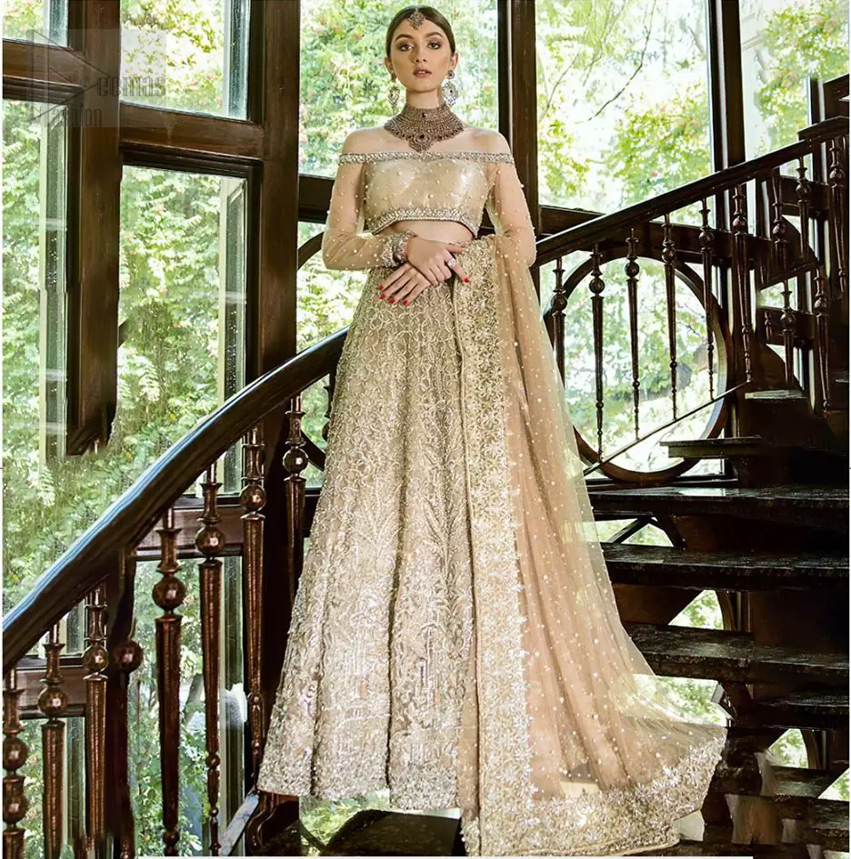 This outfit brings drama and playfulness to traditional lehenga blouse with a modern approach. Classic balanced pattern on the lehenga of tissue fabric adds exquisiteness to the look. The selection of color much of a choice for the festive season. The off shoulder blouse make a statement with light golden zardozi work. Complete the look with golden dupatta heavily embellished from all four sides and sprinkled with sequins all over.