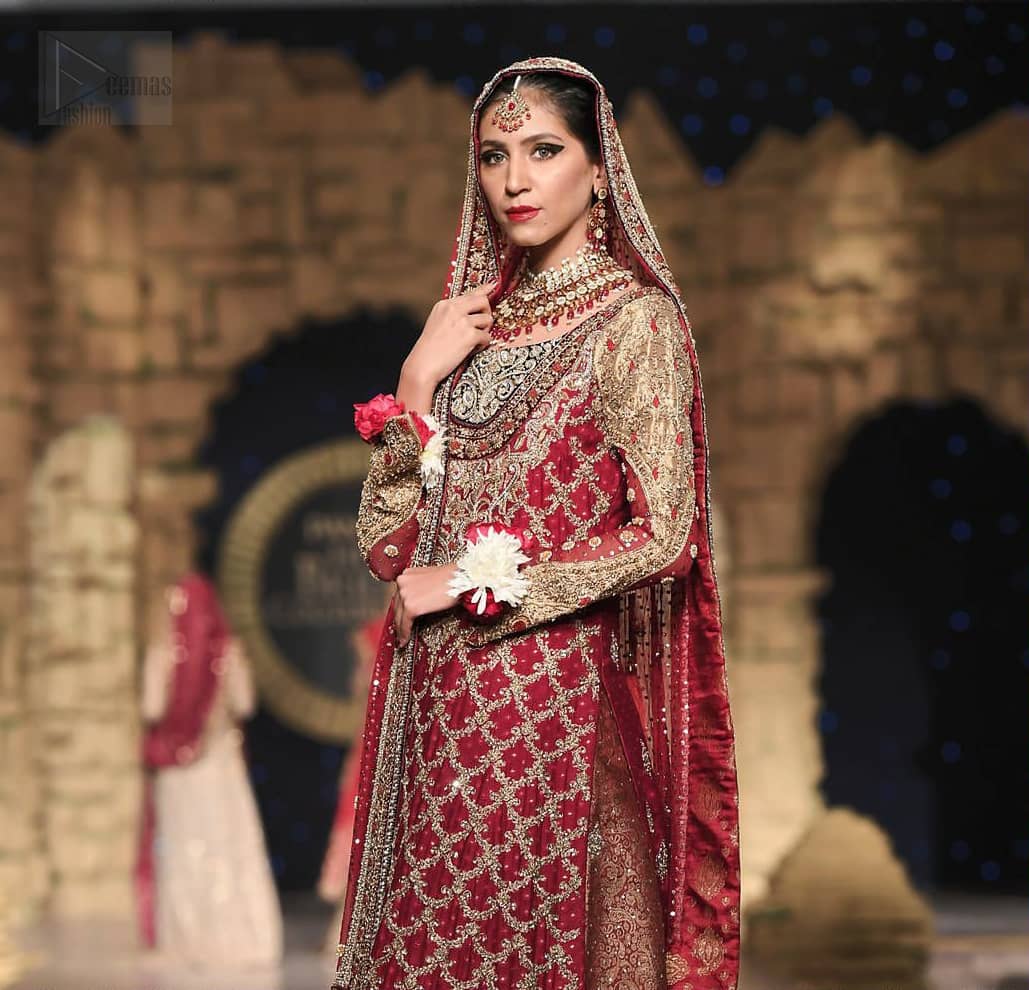 Classic, timeless and truly beautiful, our bridal dress is perfect for your unforgettable day. A perfectly pretty combination of antique and light gold embellishment, this wedding dress is elegant and eye-catching in equal measure. The bodice is crafted artfully with embellished bodice and rest of the shirt is adorned with geometric patterns. Finished with fine zardozi work on the hemline and decorative. Accompanied by a banarsi chatta patti lehenga enhanced with antique shaded kora, dabka and tilla embroidery. Finish the look with maroon organza dupatta having embroidery on all four sides.