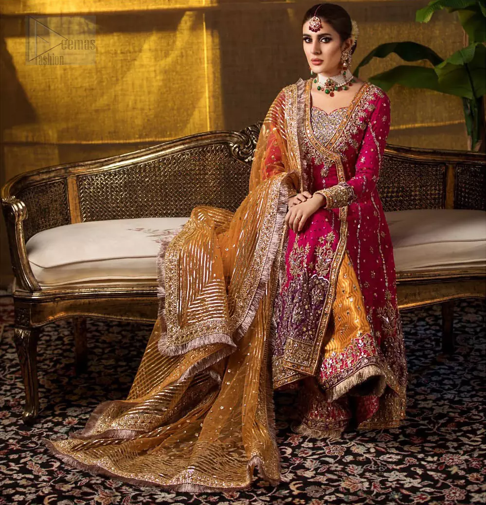 Impeccably on trend. The chic yet elegant front open angrakha style frock is decorated with vertical embroidered lines, embellished neckline and floral bunches. Borders are even more enhanced with rust applique details done with golden and light golden zardozi work. It comes with brocade rust sharara exaggerated with embroidered pink applique on the bottom. Elegance is personified when it gets paired up with rust dupatta decorated with four sided kiran lace and zardozi work on all four sides.