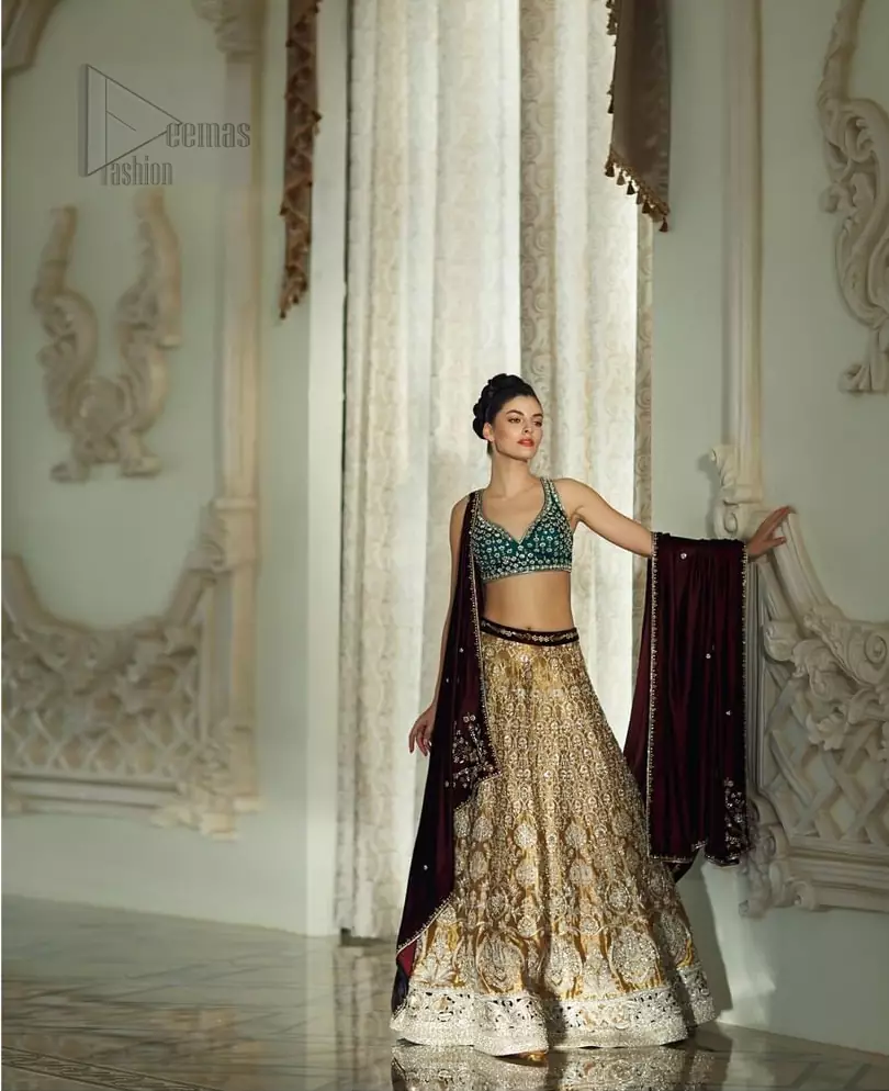 Delicately crafted and personifying chic elegance with an element of grandiose. Gussy up in this luxuriously designed lehenga blouse emboldened with intricate embroidery along with beautiful rich patterns and delicate details at the bottom. The maroon waist belt on lehenga make it so classy. It comprises with teel blouse adorned with tiny floral motifs in the shade of silver. The outfit is pair up with maroon velvet dupatta emphasized with silver and golden zardozi work on all four sides.