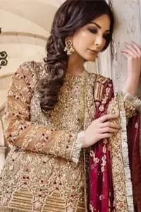 Picturing your bridal in glowing fawn colour. Featuring beautiful handwork, this outfit has a delicate arrangement of hand-embellished geometric patterns with pearls and crystals on the bottom. Refined craftsmanship is at its best with hand embellished bodice which is laden with zardozi work. This outfit is paired with organza Gharara with embroidered bottom and Kiran lace, and maroon dupatta ornamented with geometric patterns along the length, making it a statement piece. Furthermore, it is also enhanced with Kiran lace on all four sides.