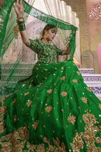 Nothing speaks of femininity and class louder than these green mehndi outfits for bridesmaids. This beautiful outfit comes with a green lehenga, which is beautifully embellished with motifs, sprinkled with sequins and finished with a thick embellished border. The blouse is breathtakingly ornamented with floral bootis, which cover every inch of the blouse. The dupatta incorporates beautifully designed scalloped borders and is frilled on all four sides. The kora, dabka, tilla, sequins and pearls work are done in shades of golden.
