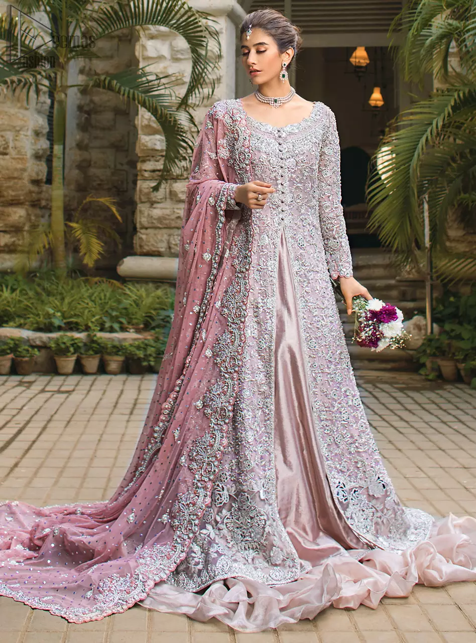 Intricate details, flamboyant silhouettes and mastery of colour are what makes this dress stand out from the rest. This is one of the elegant pieces that are sure to stay in your heart. Unique craftsmanship and detailed embellishments bring heavenly hued gossamer fabrics to life. The gown is beautifully sculptured with floral embroidery, adorned with intricately embellished borders with silver kora, Dabka, pearl and sequins work all over. Pair it up with a pink inner maxi and ruffled sharara gives the perfect ending to the outfit. The dupatta incorporates beautifully designed borders on all four sides, focusing on the heavily embellished pallu borders to give it a perfect maharani look.
