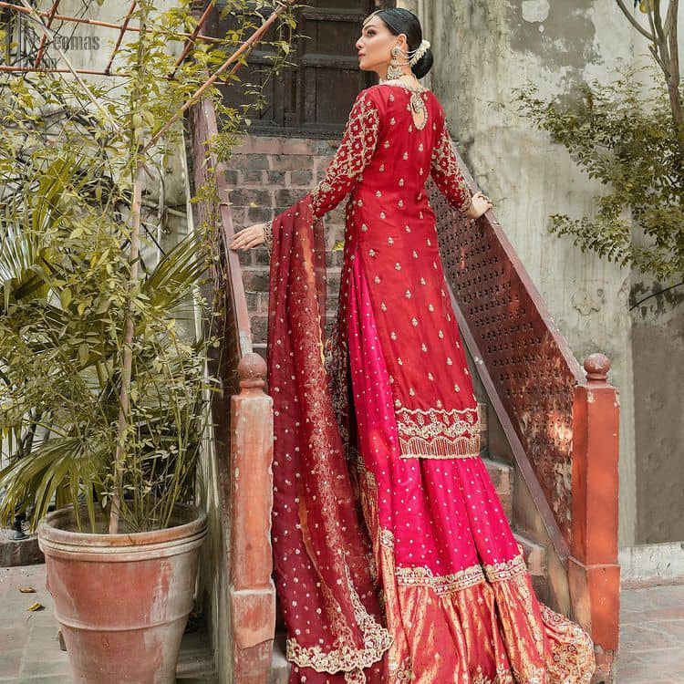 It’s ALL in the details, This breathtaking wedding dress offers comfort without compromising on style. This outfit laden with ornamental embellishments and embroidery creates such a fairytale touch to your big day. Paired with a pink sharara creates an unusual charisma wholeheartedly. Embroidery is done in the shade of golden and tiny floral motifs scattered all over the shirt. Sharara is emphasized with sequins spray and zardozi details at the bottom. Complete the look with a red dupatta having scalloped borders and scattered tiny floral motifs all over the ground.