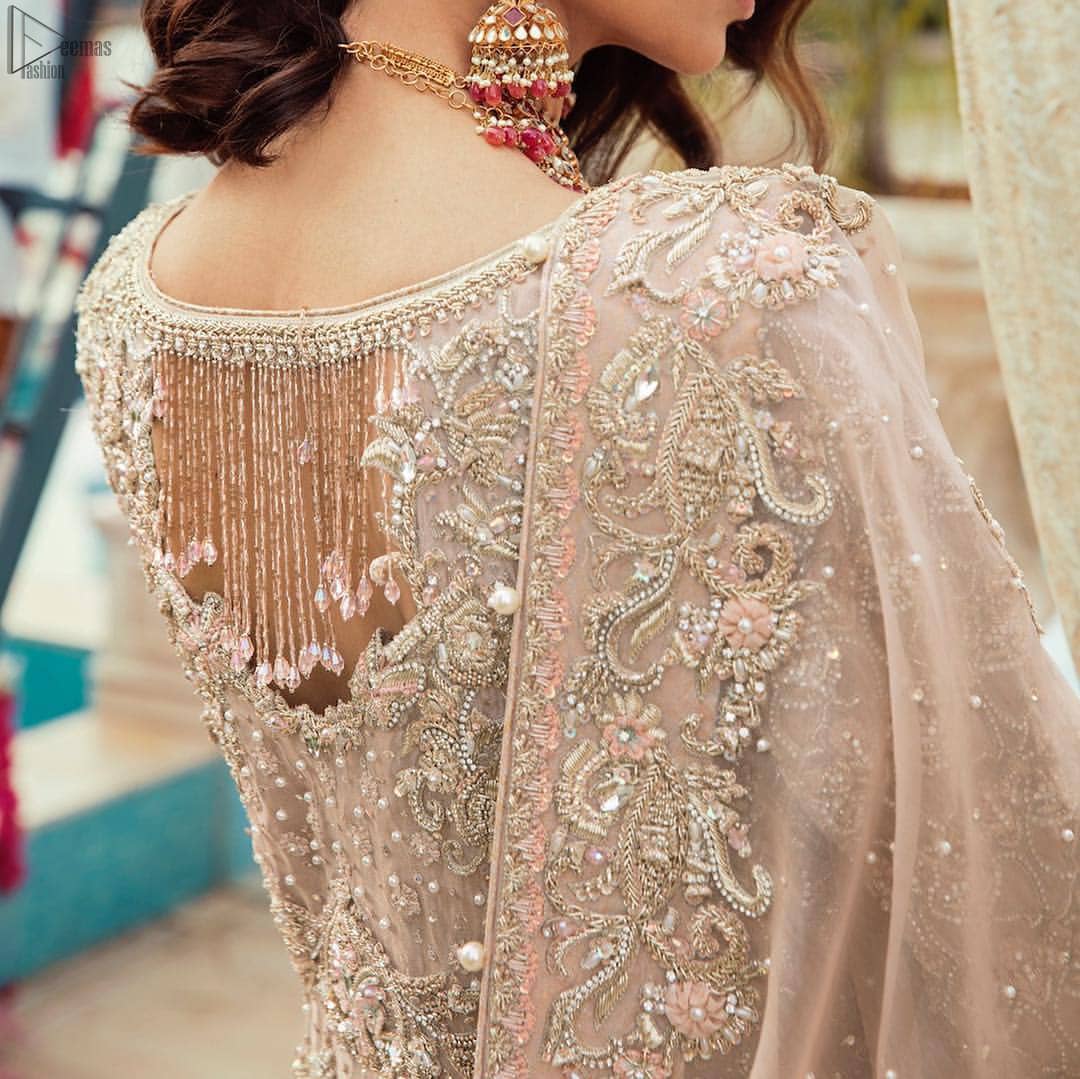 Bringing traditional charm to your big day with intricately silver and light golden embellished neckline and thick worked lines all around the flare on Tea rose canvas of Pishwas. Tea Rose pure Organza Pishwas adorned with heavy embroidery all over it. The nikah Pishwas has beautiful danglings on the back of the neckline and it comes with a pure banarsi jamawar lehenga having large thick borders on the hemline. This nikah wear tea rose Pishwas, pure banarsi jamawar lehenga comes with pure organza embroidered border dupatta.