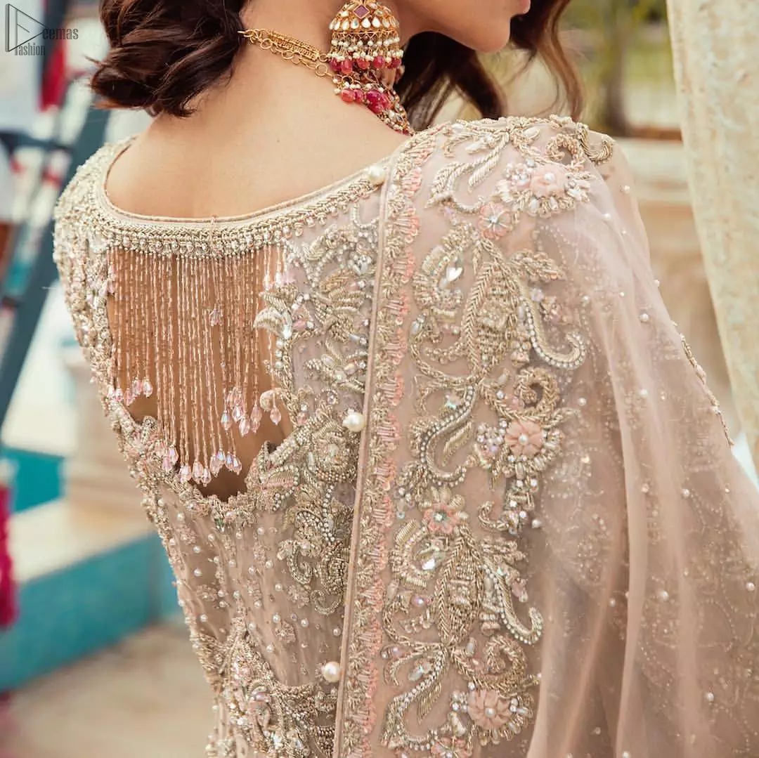 Bringing traditional charm to your big day with intricately silver and light golden embellished neckline and thick worked lines all around the flare on Tea rose canvas of Pishwas. Tea Rose pure Organza Pishwas adorned with heavy embroidery all over it. The nikah Pishwas has beautiful danglings on the back of the neckline and it comes with a pure banarsi jamawar lehenga having large thick borders on the hemline. This nikah wear tea rose Pishwas, pure banarsi jamawar lehenga comes with pure organza embroidered border dupatta.
