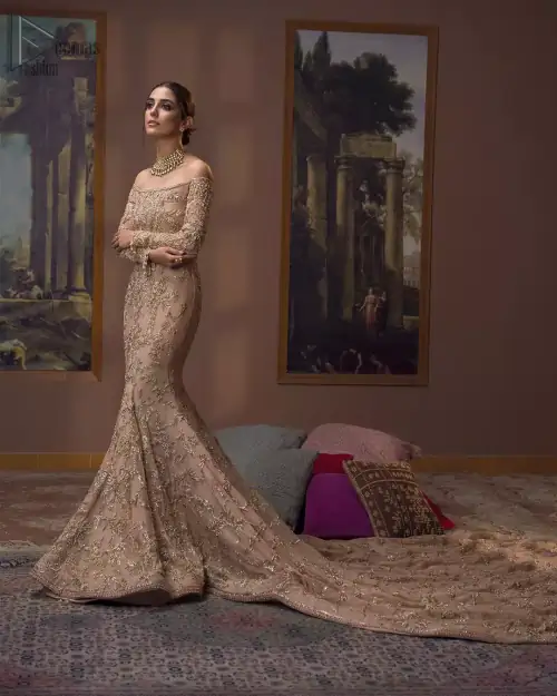 Take a step towards refreshing your wardrobe with our fawn off-shoulder back train mermaid gown. The outfit is perfected with