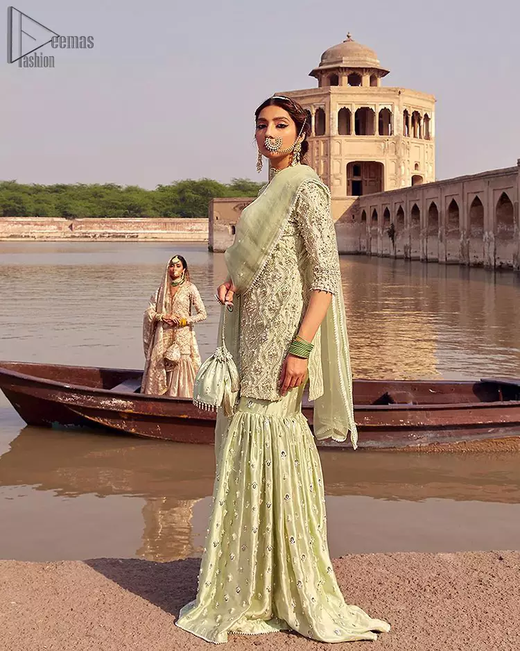 Glow up an evening formal event with a Light Parrot Green Gharara Shirt, a beautiful three-quartered sleeves shirt designed with the most accurate round neckline to make you appear the star of the night. But a star as beautiful as you need to sparkle bright, which is why the dress is adorned with an outstanding work of silver and gold embroidery and ornamented with glittering pearls. This beautiful dress is designed in a matching embellishment with criss-cross patterns to help you dress up precisely. Finally, an organza dupatta concludes your magical gorgeousness.