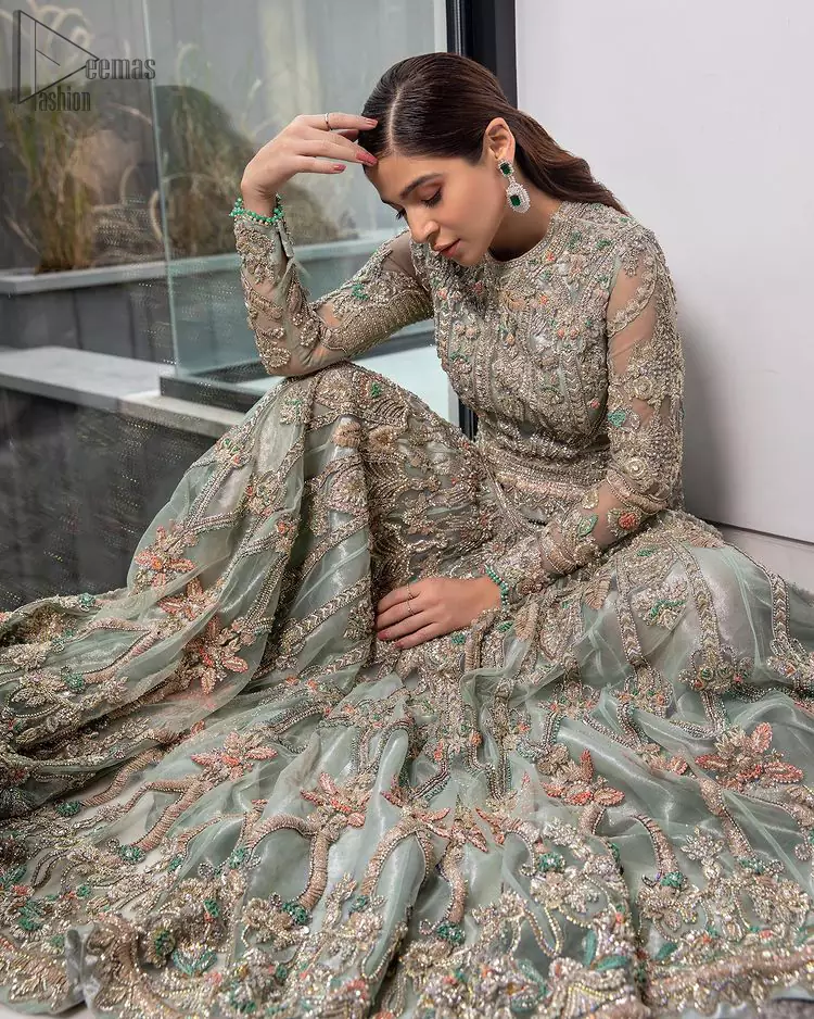 Pastel Green Large Flared Anarkali - Pakistani Wedding Gown. The bottom part of this amazing outfit comprises a lehenga with Fixed Waist Belt With Side Zip Closure. The Ivory i.e silver general embroidery with floral motifs and multicolour embroidery network on organza with finished embellished edges has its own impact. The Dupatta carried sideways have also tissue fabric with embellished four sides and finished edges. Whole this embellishment, the gorgeousness of the costume comes to the spectator noticing eye because of another unifying feature of this outfit that it is 100% imported, pure highest quality fabric.
