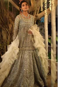 Let your flawless Nikah be a memorable one with you being the centre of admiration. The grey Lehenga Peplum is a marvellous choice for your big day. Made with pure organza the attire is beautified with silver embroidery and pearls, all synchronized nicely with the traditional trends and designs. A sweetheart neckline follows a beautiful full-sleeved peplum. While a net ivory Dupatta with a stylish criss-cross pattern concludes the dress.