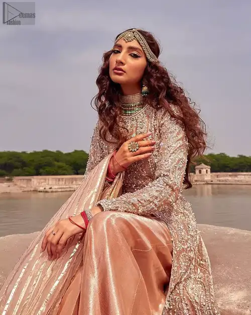 the dress with a tissue dupatta and graceful palazzo pants makes you the center of attention on your big day. Peach