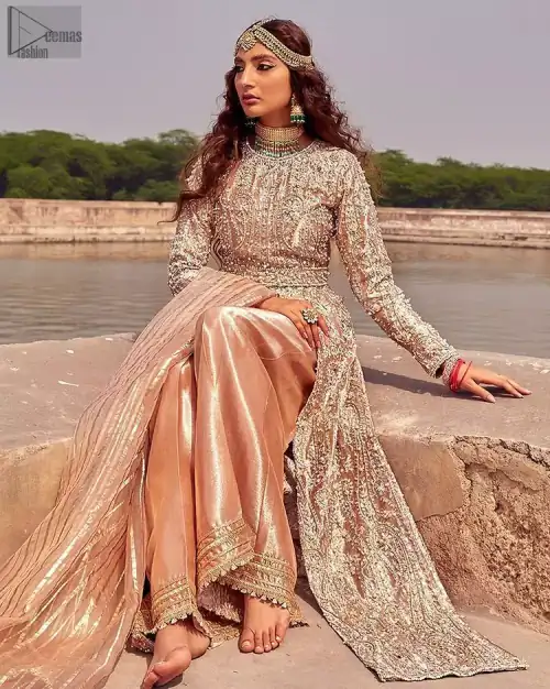 the dress with a tissue dupatta and graceful palazzo pants makes you the center of attention on your big day. Peach