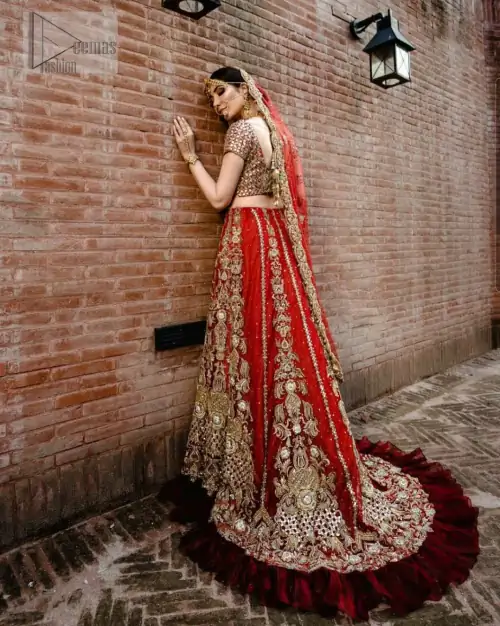 Red Ruffled Back Train Lehenga Blouse – Dupatta. It’s beautiful sweetheart neckline proceeds with mesmerizing Golden embroidery, all designed fantastically