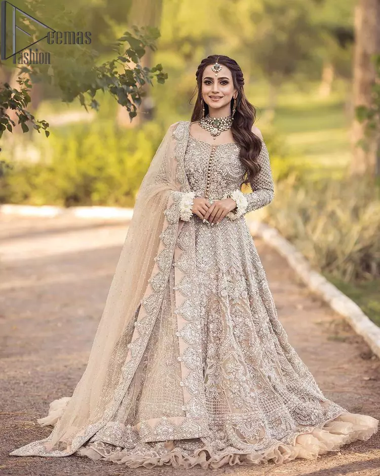 If you believed in mythical stories, shared all your secrets with glorious fairies and want to look like that mythical fairy on your reception then this Beige article is for you. This off-shoulder maxi is beautifully embellished with kora, dabka, tilla, sequins and pearls work, style up with remarkable full sleeves. Introducing this with a ruffled lehenga that looks super stunning and priceless. Followed with a net dupatta that is prominent with hand embellished borders and sequins spray all over that enhances the beauty of the outfit and give you a mythical fairy look as well.
