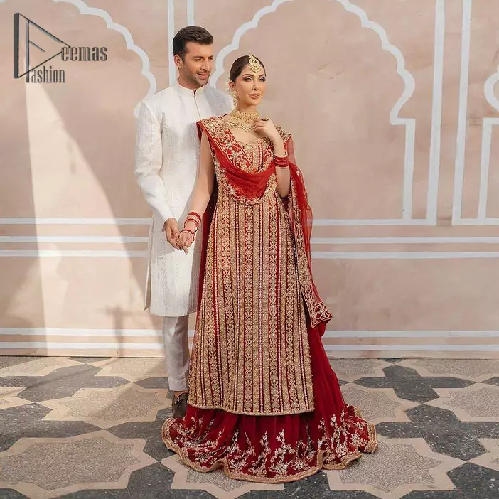 This stunning wedding dress offers comfort without compromising on style. The outfit is laden with golden zardozi work all over the shirt. embroidery creates such a dreamy touch to your big day. Paired up with a red lehenga adorned with floral bunches all around the flare creates an unusual design. Embroidery is done in the shade of golden. Dupatta is accentuated with sequins spray all over and hand-embellished floral jhaal all around the borders.