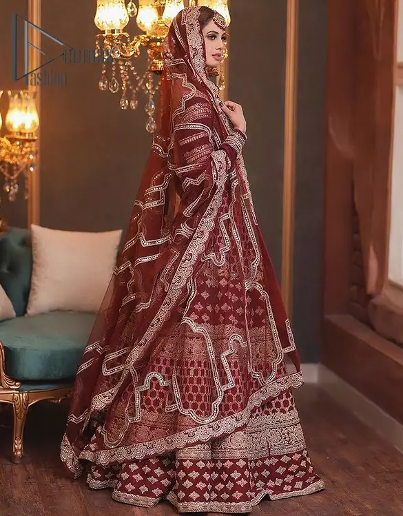 Attain your expectations on your big day with this mesmerizing dress. The classically vibrant combination of red and gold is a true image of elegance. The full-sleeved red blouse made with pure organza is encapsulated with boat shape neckline that follows light golden embroidery. In addition to this, the lehenga having geometric pattern embroidery that embellishes with tilla , dabka and kora work gives you incredible look on your big day. This engaging dress comes with a dupatta having four sides embellishment borders.