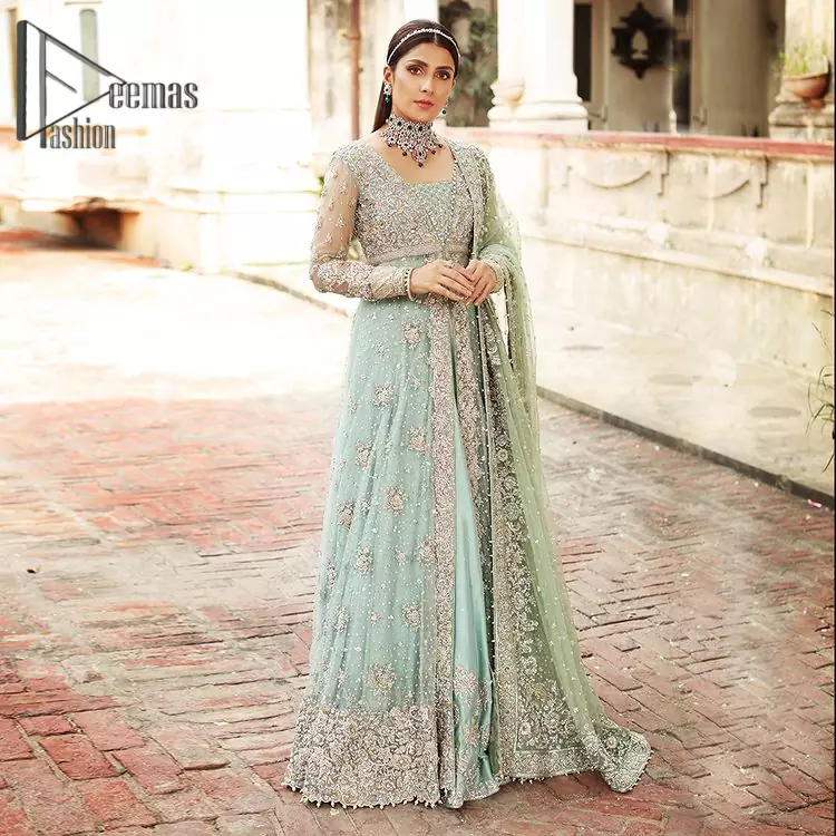 Stressed about your outfit on Walima? Deemas Fashion will save your day. Make your moments more memorable with our ice blue front open maxi that is adorned with silver tilla, kora, and crystal work to enhance the beauty of maxi. In addition to this, the beauty of the square neckline of the stunning maxi speaks itself on your day. It is synchronized with the lehenga that's border is as pretty as look in the picture. Finish this look with dupatta that personifies the delicate embroidery on four sides and sequins detailing all over just to save your memorable day and give you fairy look.