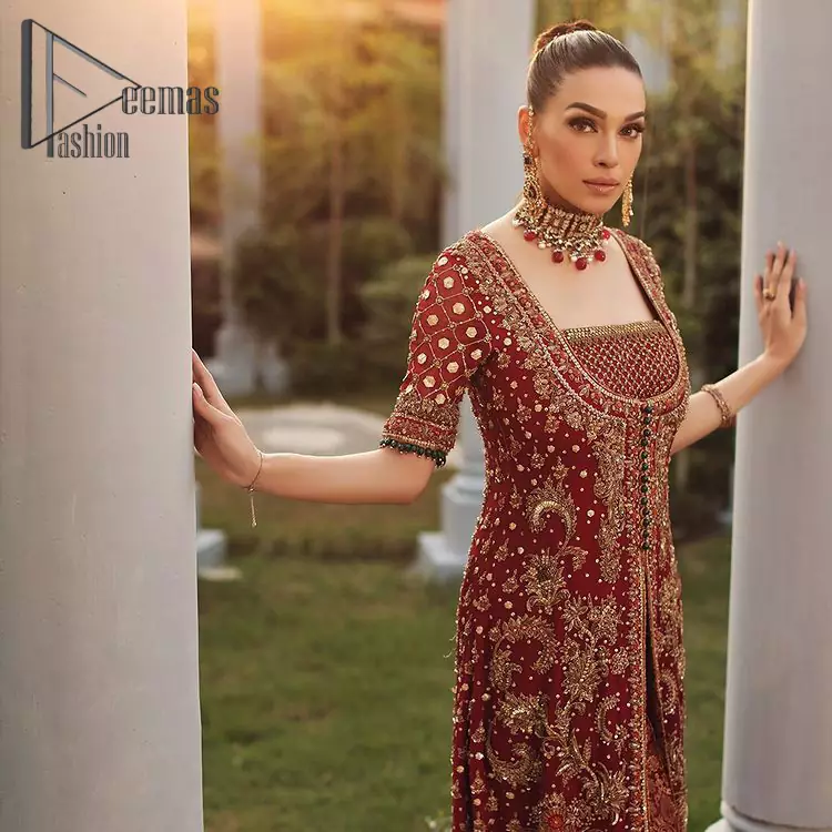Just fulfil your love for maroon on your Big day with DeemasFashion. Giving you all the glam with this maroon scalloped front open frock which is beautifully sprinkled with antique tilla, dabka, kora, crystal, and Resham thread work. In addition to this, the square neckline and half sleeves with multicolor embroidery look so stunning and soothing on your Big day. It is attractively synchronized with cigarette pants to grant you a remarkable aesthetic focusing look.

