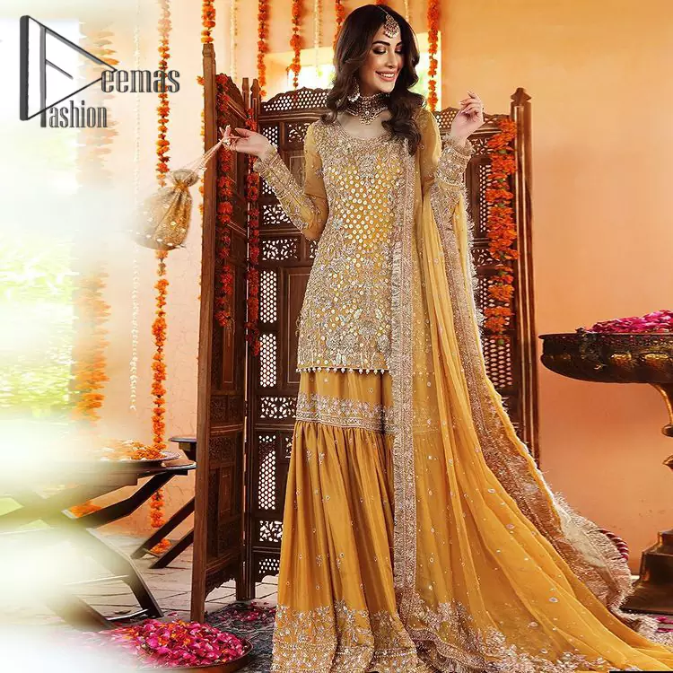 The shirt is the mirror of the mind and the dupatta confesses secrets of the heart. This mustard soft-toned article is highlighted with fascinating silver kora, dabka, and crystal work. The shirt is further enhanced your mayon look with a traditional round neckline and full sleeves. It is paired up with gharara that is prettified with priceless border embroidery. Finish this look with the same color dupatta that have four-sided embellished lace and Kiran. Further the sequins spray on the dupatta increases the beauty of the article which is every bride's dream.