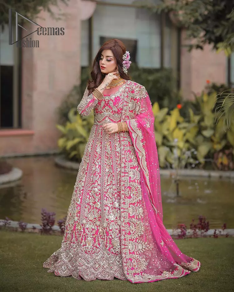 A colour splash, a floral dream. Let your energy shine with this pink outfit. Make a dramatic entry with pink scalloped pishwas that’s full sleeves look super-duper amazing when combine with boat shape neckline. It is streaking with the finest silver and light golden embroidery that counts in tilla, kora, dabka, and crystal work to give you an enthusiast look. Further, this scalloped pishwas is coordinated with a Pink dupatta that is adorned with four-sided borders and sequins spray all over to give you shiny energy at any party.
