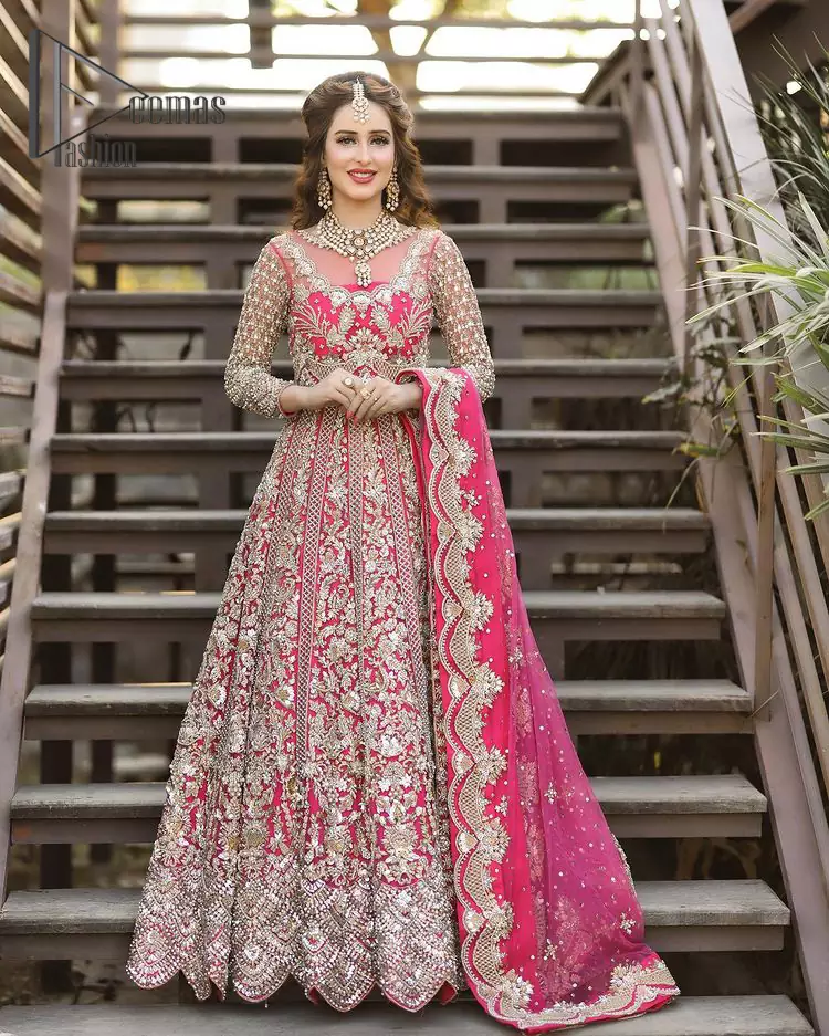 A colour splash, a floral dream. Let your energy shine with this pink outfit. Make a dramatic entry with pink scalloped pishwas that’s full sleeves look super-duper amazing when combine with boat shape neckline. It is streaking with the finest silver and light golden embroidery that counts in tilla, kora, dabka, and crystal work to give you an enthusiast look. Further, this scalloped pishwas is coordinated with a Pink dupatta that is adorned with four-sided borders and sequins spray all over to give you shiny energy at any party.
