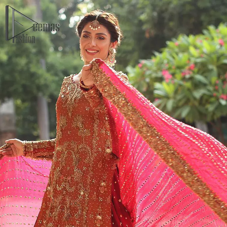 Wondering what an aesthetic bridal attire looks like? The beauty in red makes you go gaga over your look and you cannot stop snowing over you. Wearing the rust long shirt on your big day that is marvellously adorned with kora, dabka, and sequins work. Furthermore, the round neckline is also beautifully decorated to enhance the beauty of the outfit. It is synchronized with a red lehenga that has sequins sprayed all over to give you a crazy look as well. Finish this look with a red dupatta that has four-sided embellished borders as well.