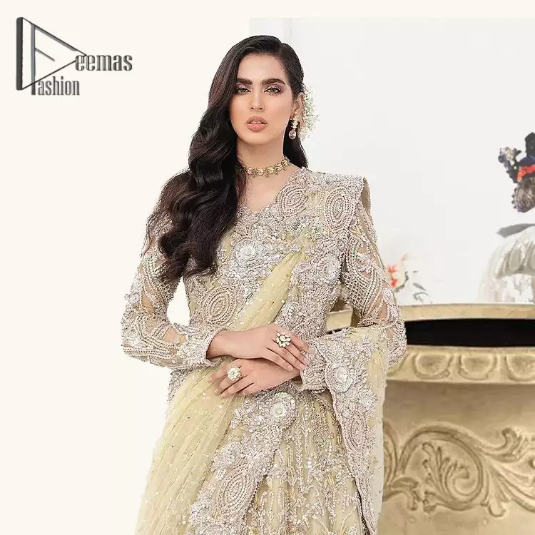 A dream come true for girls who love to play with their looks in a fashionable look. We don't even miss adding the finest details to our outfits so that's why the blouse is embellished with silver embroidery that involves kora, dabka, and tilla work to shoot up the first-rate look. Furthermore, the full sleeves of blouse and round neckline gives so splendid look when comes together.Gracefully, It is pair up with stunning and beautifull vanilla lehenga to fulfill your dream. Finish this look with dupatta that is embellished with four-sided borders and sequins spray all over to give you a fashionable look.