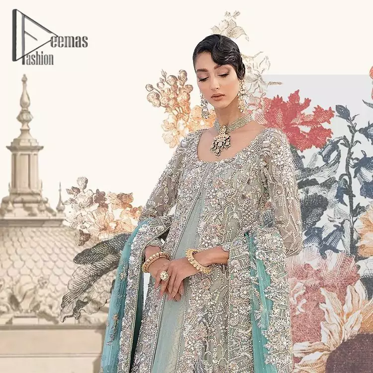 Sync. Style. Slay! A wedding is better when you get a super stylish all-in-one. DeemasFashion presents you with an ice-blue front open maxi this is decorated with silver embroidery which involves tilla, dabka, kora, and pearls work to magnify your inner pleasure on your Walima day. It is dominant with full sleeves just to grant you an aesthetic look. It is attractively coordinated with an ice blue lehenga with back train styling to give you a fairy look. Complete this outfit with the same colour dupatta that is beautifully embellished with floral motifs and a four-sided border.