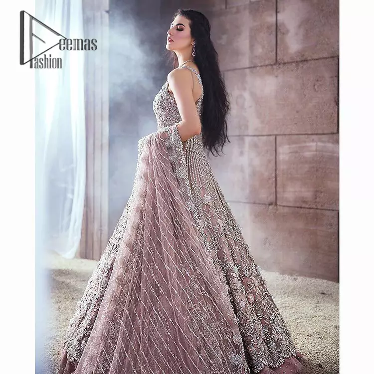 Rose, glitter, and glam are the mood. Shine through with all eyes on you! A full festive package dipped in an oyster pink tone. Presenting oyster pink front open maxi for your walima day just to boost up your inner happiness. The maxi is handsomely adorned with silver embroidery that is embellished with tilla, kora, dabka, and pearls work. Furthermore, it is highlighted with full sleeves just to give you a glam and shiny look. It is systemized with an oyster pink lehenga to give you a superstar look. End up this article with the same color dupatta that is prominent with a four-sided embellished border and sequins spray all over.