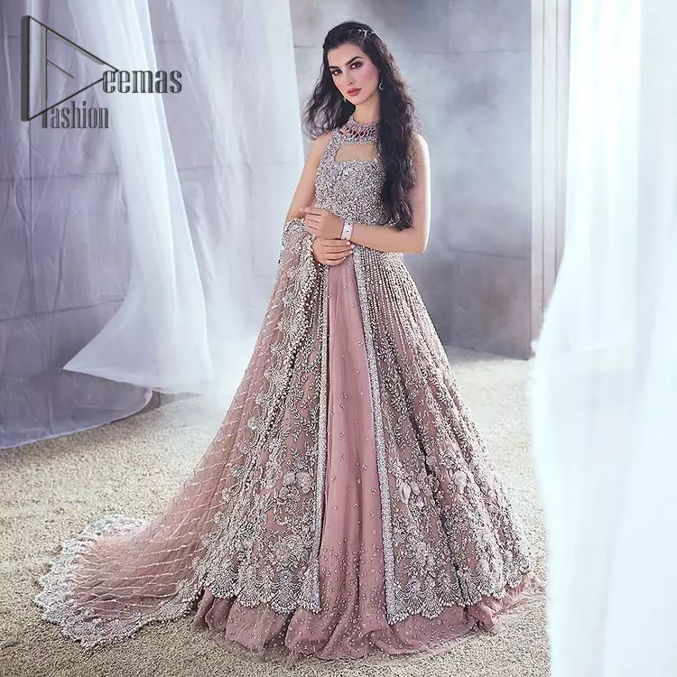 Rose, glitter, and glam are the mood. Shine through with all eyes on you! A full festive package dipped in an oyster pink tone. Presenting oyster pink front open maxi for your Walima day just to boost up your inner happiness. The maxi is handsomely adorned with silver embroidery that is embellished with tilla, kora, dabka, and pearls work. Furthermore, it is highlighted with full sleeves just to give you glam and shiny look. It is systemized with an oyster pink lehenga to give you a superstar look. End up this article with the same colour dupatta that is prominent with a four-sided embellished border and sequins spray all over.
