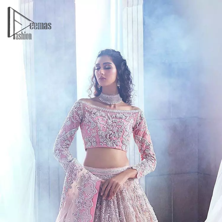 DeemasFashion just defines sophistication and minimal high fashion in terms you desire. Reveal your aura in this tea pink off-shoulder blouse that is beautifully decorated with silver embroidery that involves a kora, dabka, tilla, and crystal look just to grant you mesmerizing look. Further, the full sleeves of the blouse look so admiring on your walima day. It is arranged with a frilled lehenga again which is ornamented with heavy silver embroidery so that you can steal everyone's heart. Finish this article with a tea pink dupatta that is prominent with four-sided border embellishment.