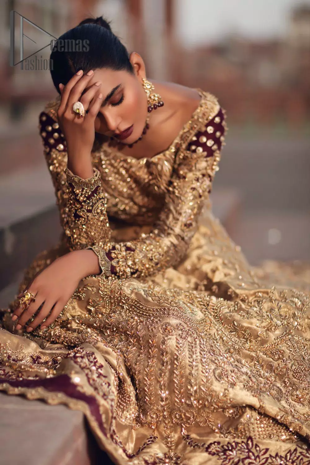 Adorn yourself in the layers of golden that feel rich on the skin. This outfit which is starting with a blouse beautifully laden with golden embroidery that includes kora, dabka, tilla to give you a traditional bride look. It is highlighted with boat shape neckline and super aesthetic full-sleeves to enhance your emotion of you on your Big Day. It is systematically arranged with a two-tone lehenga which is prominent with back train style and heavily adorned with embroidery. Finish this article with a golden scalloped dupatta that is embellished with four-sided borders and sequins sprayed all over. 