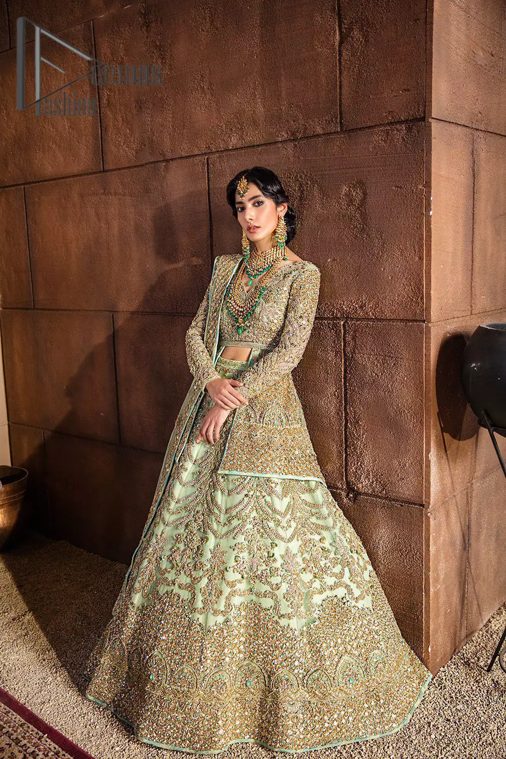 She was a dreamer, and so are we. A pistachio green front open short frock serves as a canvas for gold and pistachio green work with the magic of tilla, dabka, semi-precious stones and pearls. The V shape neckline is highlighted with full sleeves to add a galaxy in eyes of every bride. In addition to this, it is organized with the same colour fluffy lehenga which is again adorned with heavy golden embroidery to express the love of the bride on her walima day. Finish this outfit with the same colour dupatta which is embellished with four-sided borders and sequins sprayed all over.  