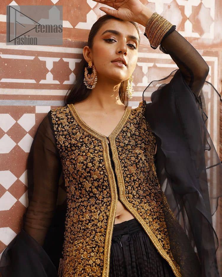 With the timeless charm of black so back on traditional flavour to steal everyone's heart. Introducing the black jacket that is the epitome of splendour with delicate details beautifully decorated with golden colour. The bodice of the jacket is enhanced with stunning embroidery with worked finishing of tilla, kora, dabka and zardozi. The addition of simple sleeves with V shape neckline can be done to make this super traditional. To complete this traditional jacket, a crushed sharara is added to give you an amazing look at any formal event. Complete this black outfit with a black dupatta in a plain style that is perfect for any intimate evening 