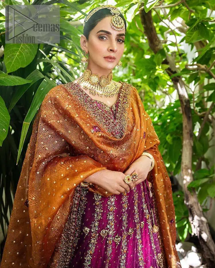 The outfit defines the true essence of allure with its spellbinding magenta hue and intricate details. The blouse is decorated