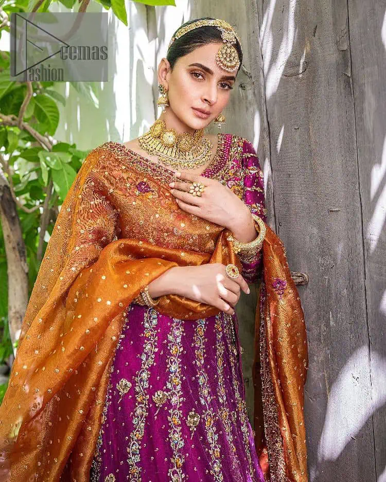 The outfit defines the true essence of allure with its spellbinding magenta hue and intricate details. The blouse is decorated