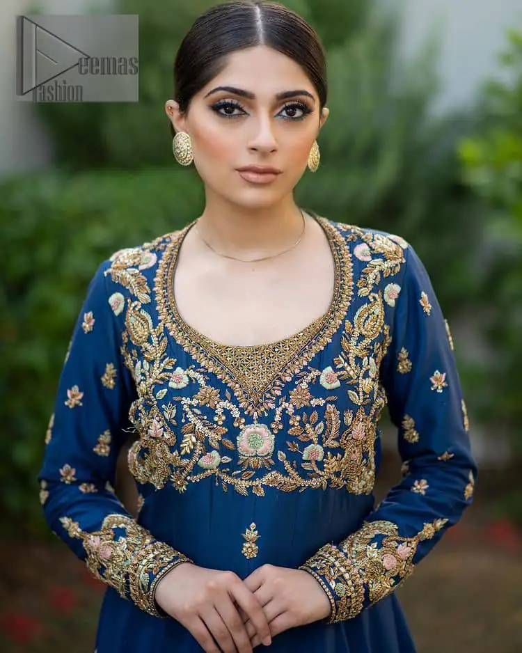 Hues of blues make a funky yet amazing pattern on amazing events. DeemasFashion introduces a navy blue outfit. Starting this article with a navy blue multiple panel frock which is ornamented with golden embroidery. The pattern of embroidery begins with the round neckline which is handsomely embellished with tilla, dabka, kora and Kundan. It is further prominent with full sleeves. The rest of the frock is decorated with floral motifs in a golden hue. The following frock comes with a golden dupatta to complete the admiring look on any day or night event. 