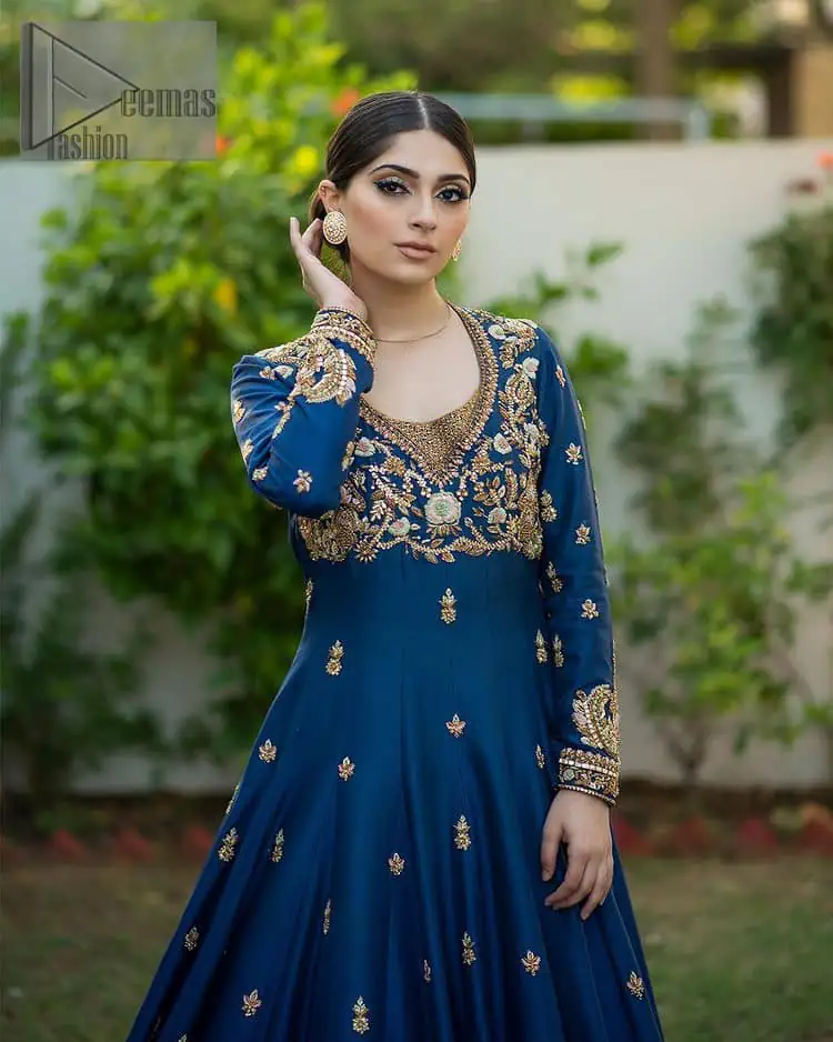 Hues of blues make a funky yet amazing pattern on amazing events. DeemasFashion introduces a navy blue outfit. Starting this article with a navy blue multiple panel frock which is ornamented with golden embroidery. The pattern of embroidery begins with the round neckline which is handsomely embellished with tilla, dabka, kora and Kundan. It is further prominent with full sleeves. The rest of the frock is decorated with floral motifs in a golden hue. The following frock comes with a golden dupatta to complete the admiring look on any day or night event. 