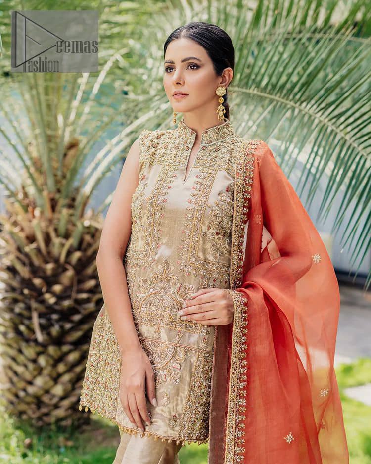 Envelop yourself into a dazzling love affair. The unique article in ivory colour just highlighted you at any event. The short shirt of the article is handsomely decorated with golden embroidery which includes kora, dabka, tilla, Kundan and Sitara work to make your event blazing and dazzling.  It is enhanced with a collared neckline to make this outfit more formal when come with a sleeveless style. Further, it is coordinated with pant which is embellished with golden embroidery. Last but not least piece the dupatta comes in rust colour having four-sided embellished borders to encapsulate you in stars.