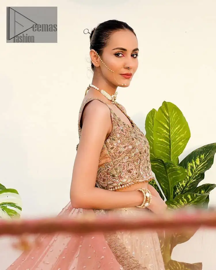 The perfect outfit for walima to enhance your glow. Starting this article with a dream rust blouse having a strap neckline and prominent sleeveless style to embrace the romantic culture. The following blouse is fully embellished with golden embroidery that is prominent with tilla, dabka, kora, pearls and sequins spray to fulfil your dreamy look. It is coordinated with an ivory can-can lehenga whose border is again rendered with golden embroidery and sequins sprayed all over to continue the look. Complete this outfit with a rust dupatta which is embellished with four-sided borders and sequins sprayed all over to enhance the glow of the bride.